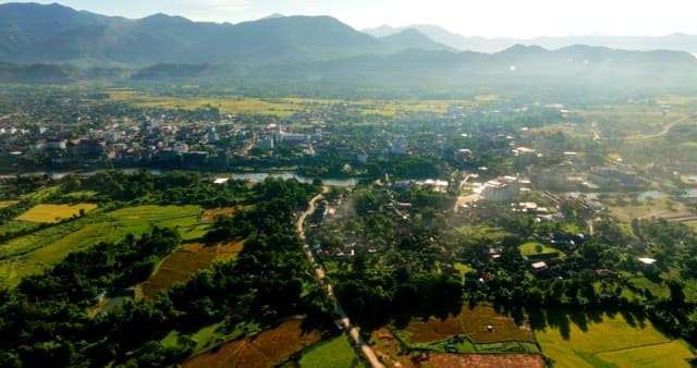 Aerial View of a Lush Town by Mountains