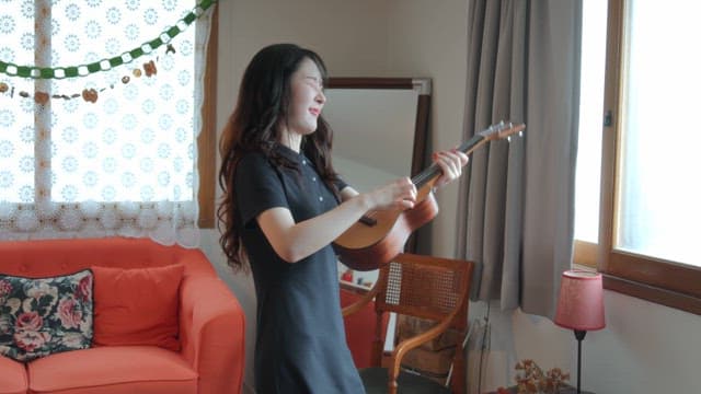 Woman playing a ukulele indoors