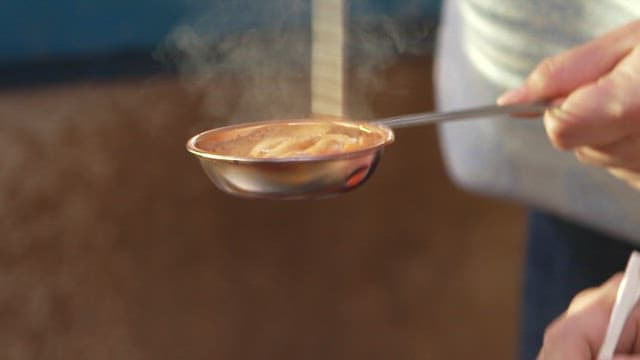 Stirring melted sugar vigorously to make dalgona