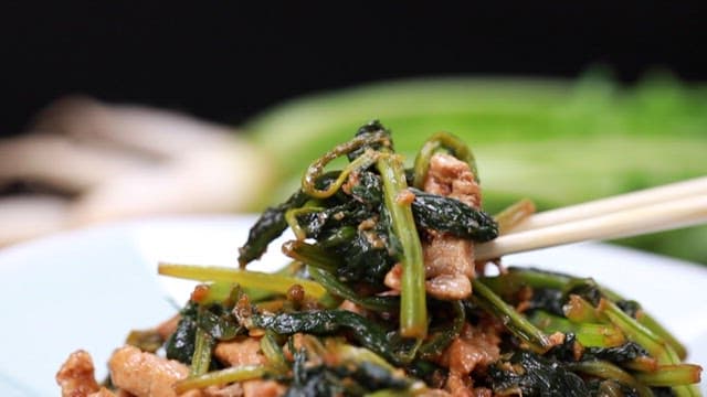 Chopstickful of stir-fried pork and young radish leaves