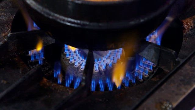 Earthen pot on a gas stove with blue flames