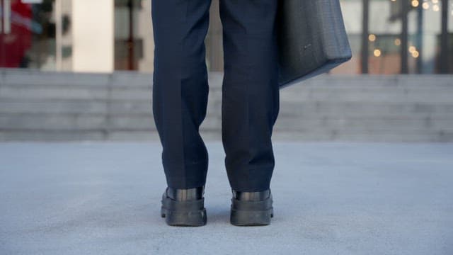 Person with briefcase walking to building entrance