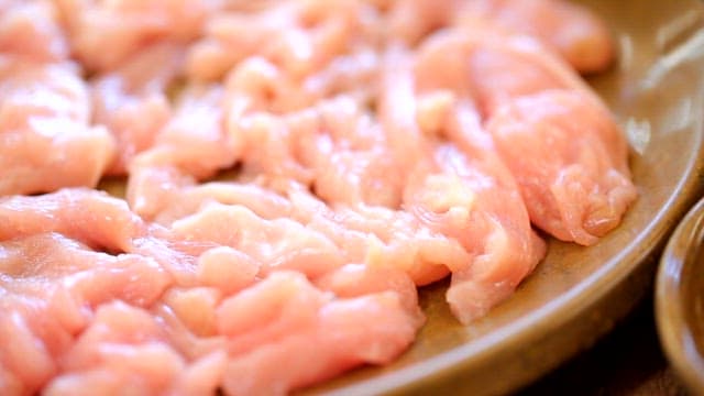 Raw chicken slices on a plate