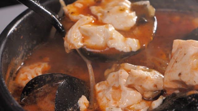 Ladleful of spicy soft tofu stew with mussels