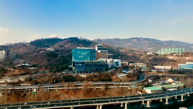 Cityscape beside a River with Forested Hills