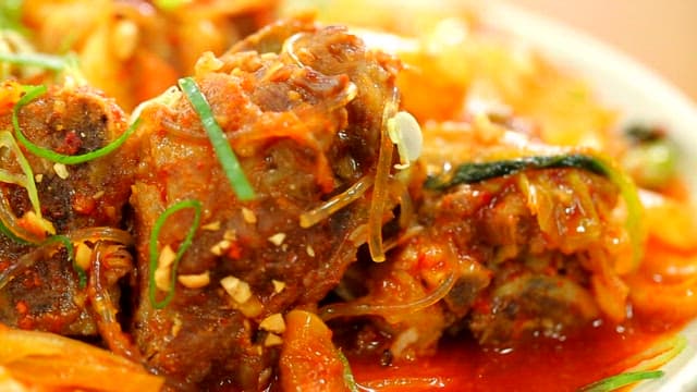 Spicy braised pork backbone topped with green onions