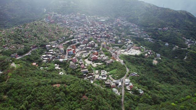 Aerial view of a hillside town with lush greenery