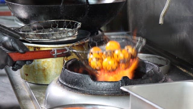Grilling fresh tangerines on a cooking stove in the kitchen
