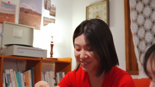 Woman in red sweater playing cards indoors