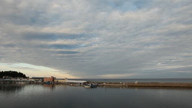 Coastal Town with Boats and Cloudy Sky