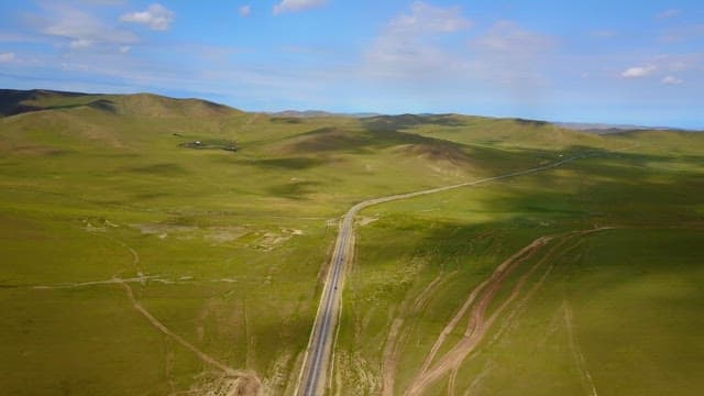 Vast green landscape with a winding road