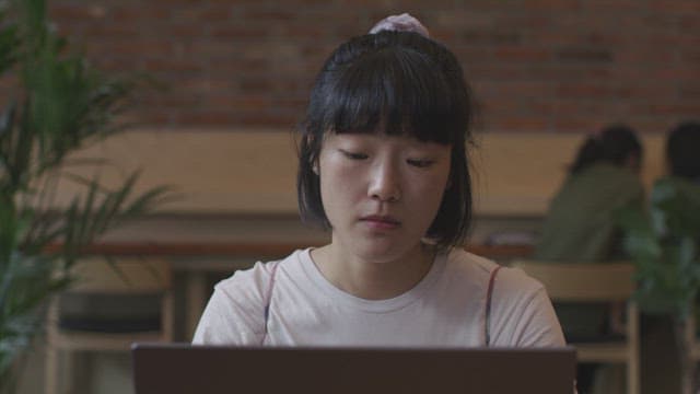 Woman working on a laptop in a cozy cafe