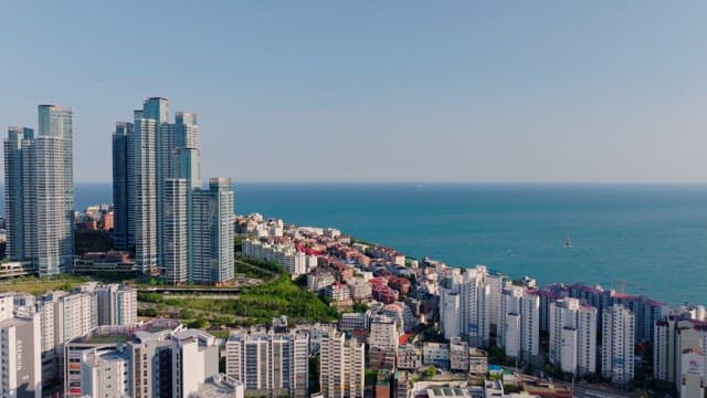 Coastal city with tall skyscrapers and dense residential complex by the sea