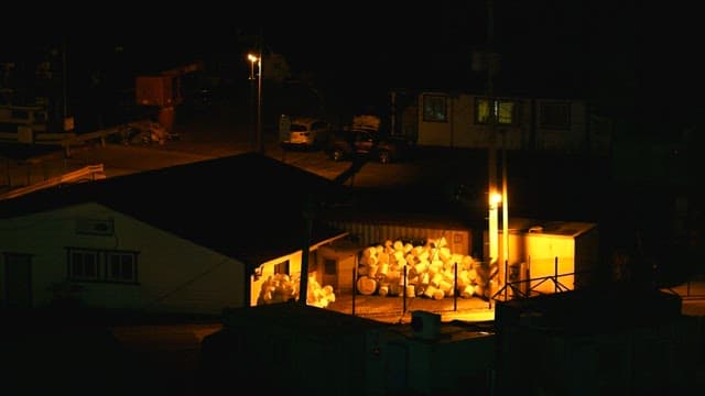 Industrial site at night with stacks of materials
