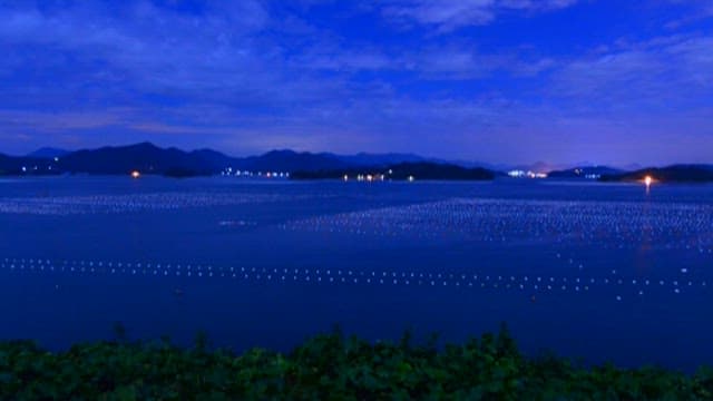 Sunset over the sea with a fish farm