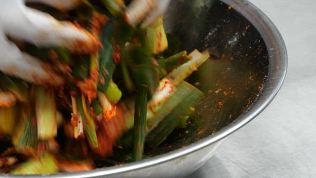 Adding green onions mixed well with red pepper powder into the stew