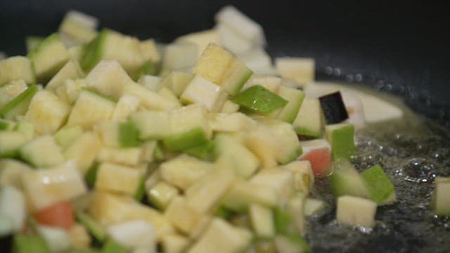 Diced vegetables sizzling in a frying pan