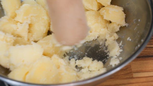 Mashing and Mixing Potatoes in a Metal Bowl