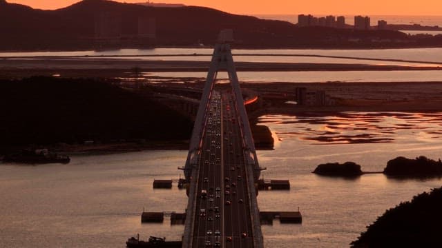 Bridge over water at sunset with traffic