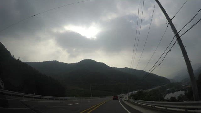 Driving through mountainous terrain during cloudy weather