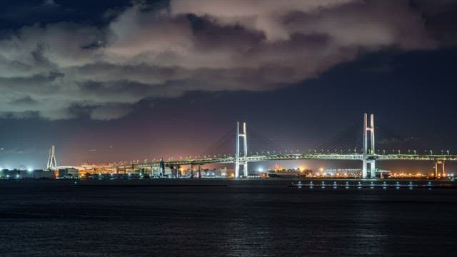 Illuminated bridge over a cityscape at night