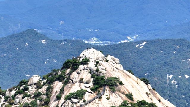 Buramsan mountain peak with hikers and lush greenery