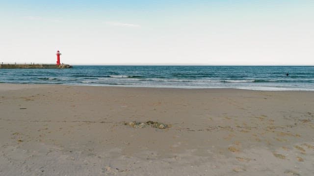 Serene Beach with Red Lighthouse