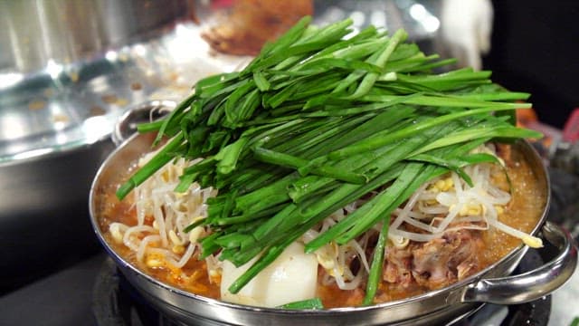 Pork backbone stew topped with chives and bean sprouts