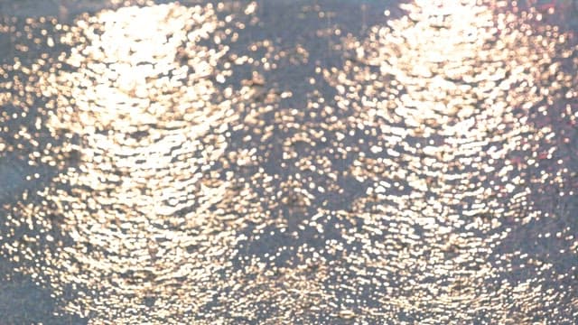 Raindrops creating ripples on a pavement