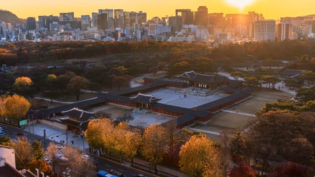 Timelapse of a historic palace with a city skyline at sunset transitioning to night