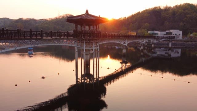 Traditional pavilion on a serene lake at sunset
