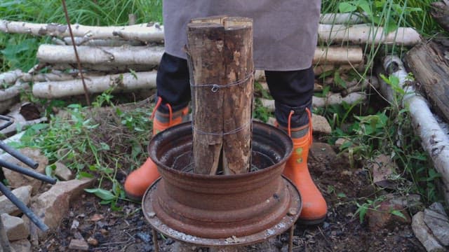 Person preparing wood in a rustic setting