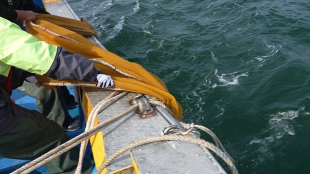 Fishermen on a fishing boat handling a large net in the sea