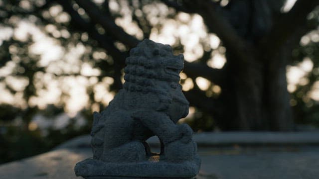 Stone guardian lion at dusk with sun