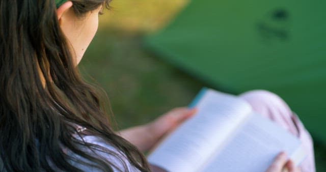 Woman Reading Book Outdoors in Sunlight