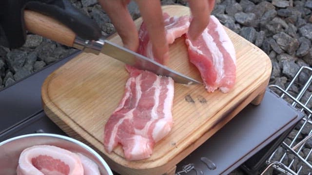 Fresh pork belly grilled on a camping grill