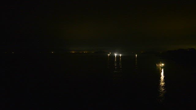 Night fishing boats with lights on the water