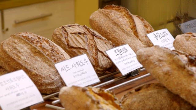 Various types of artisanal sourdough bread displayed in a bakery