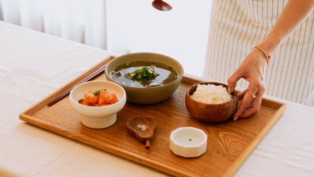 Person Mixing Rice with Warm Beef Soup