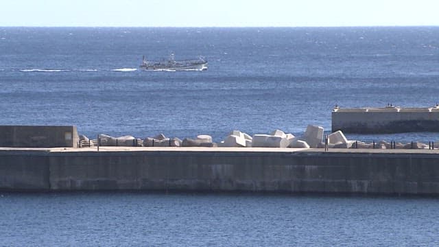 Boat passing by a coastal breakwater