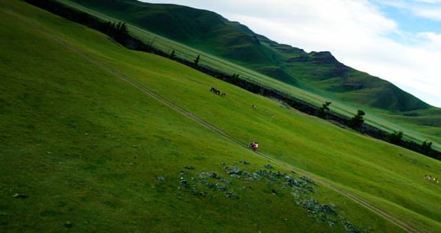 Motorcycle riding through green hills