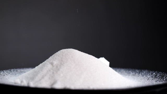 Sugar cubes falling on a pile of granulated sugar