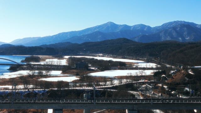 Mountains Overlooking a Frozen River and Roadways