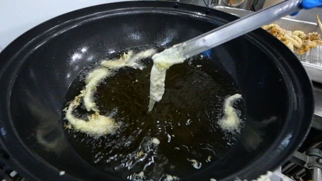 Deep frying webfoot octopus in hot oil