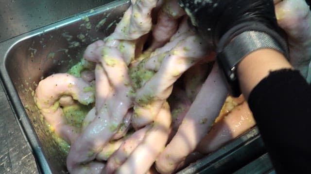 Seasoning tripe in a metal container in the kitchen