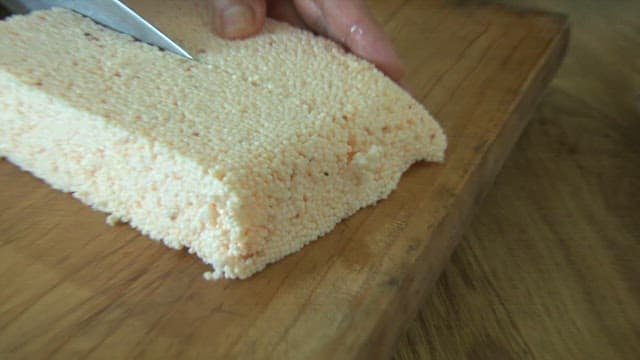 Person cutting tofu made from fish eggs