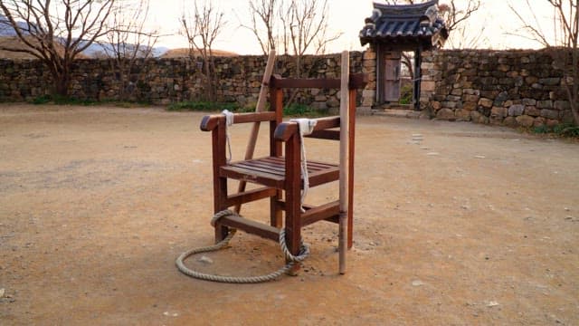 Wooden chair with a rope tied to it, used as a traditional Korean interrogation instrument