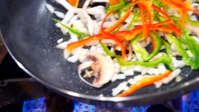 Vegetables being stir-fried in a pan
