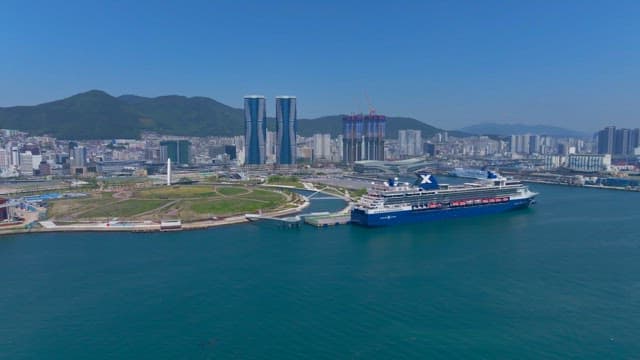 Panoramic view of a coastal city with a huge cruise ship anchored