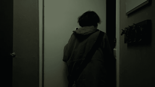 Woman opening the front door of her apartment and going out